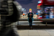 © Westend61 - Woman using smartphone at night on London street with city lights