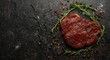 © AkuAku - Overhead view of organic beef steak seasoned with herbs on dark surface with copy space