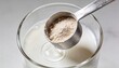 © xuxu - Protein blend: one scoop of white powder per glass of liquid; ideal for use in healthcare, sports, nutrition, and as a dietary supplement. See light background.