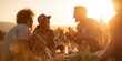 © fotofabrika - Friends enjoy food and laughter during sunset in a field on a warm evening