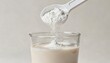 © xuxu - Protein blend: one scoop of white powder per glass of liquid; ideal for use in healthcare, sports, nutrition, and as a dietary supplement. See light background.