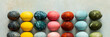 © pundapanda - A beautiful array of hand-dyed Easter eggs in various colors, neatly arranged in rows. This colorful display celebrates the spring season and Easter traditions with creativity, banner