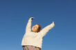© Anna - sweet, freedom-loving, happy young European woman enjoys the moment, raising her arms to the sun under a cloudless sky. love life, well-being, positive thinking, and dreams. A spring walk outdoors