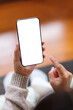 © Farknot Architect - Vertical top view mockup image of a woman holding and using mobile phone with blank desktop screen at home
