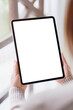 © Farknot Architect - Vertical mockup image of a woman holding tablet with blank desktop white screen on the bed at home