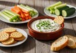 © PhotoHub - Delicious spinach and artichoke dip served with crackers and fresh vegetable sticks on a wooden table
