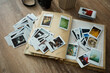 © mira_y - Collection of printed photos scattered across a table next to a photo album and camera during afternoon light