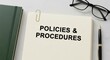 © Stocker Girl - A notebook page displaying policies and procedures with office supplies nearby.