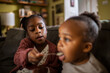 © Marko Geber - Older child feeding toddler with spoon at home