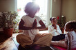 © Marko Geber - Mother and daughters meditating on yoga mats at home