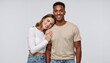 © Vasiliy - Interracial couple standing together against a neutral studio background. Happy young man and woman in a supportive relationship. Diversity and togetherness concept