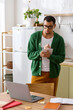 © LIGHTFIELD STUDIOS - Young man enjoying creativity in a cozy home environment while working on a notebook