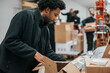 © Maskot - Male worker packing cardboard box in warehouse