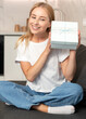 © brizmaker - Happy woman smiling and holding gift box in hands