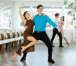 © JackF - Couple of young guy and young women dancing tango dance in studio