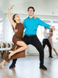 © JackF - Girl and guy in festive clothes dancing slow ballroom dance during group lesson in a choreography studio