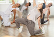 © JackF - Positive young lady engaged in break-dance together with other attendees of dancing courses
