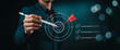 © Mehdi - Business goal setting concept with businessman using digital stylus to target center of dartboard, symbolizing strategic planning, objective alignment, achievement checklist for organizational success