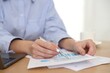 © New Africa - Secretary with pen doing paperwork at table in office, closeup