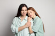 © New Africa - Mother and her teenage daughter on grey background