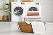 © Pixel-Shot - Basket with clean bed sheets in laundry room