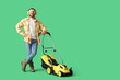 © Pixel-Shot - Young man in hearing protectors with lawn mower on green background