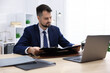 © New Africa - Notary working at wooden desk in office