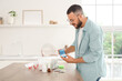 © Pixel-Shot - Young man with pill box and first aid kit at table in kitchen