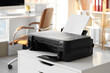 © Pixel-Shot - Modern printer with paper sheets on chest of drawers in office