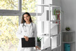 © Pixel-Shot - Young female doctor with clipboard near window in clinic