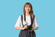 © Pixel-Shot - Beautiful young woman with modern camera on blue background