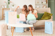 © Pixel-Shot - Surprised young women unpacking shopping bags for Easter at home