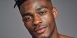 © NovaVision - Close-up portrait of a young Black man with a confident expression and stylish haircut