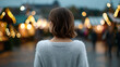 © Moddy - A woman is looking at festive lights, enjoying the atmosphere. The shot has shallow depth of field, with the woman in focus and the lights blurred in the background.
