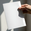 © Selim - A hand holding a piece of paper with a unique cut-out shape.
