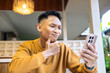 © Alfian Muzaki - Confused Asian man thinking while looking at his smartphone