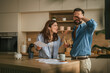 © Miljan Živković - Couple arguing over finances in kitchen while dealing with stress