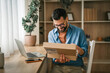 © Miljan Živković - Man receiving package for home online shopping delivery