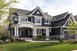 © Her - Dark gray shingled house with stone accents and manicured lawn.