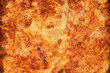 © nahhan - A detailed macro shot of a freshly baked lasagna showing the crispy golden brown cheese crust and rich bubbling meat sauce texture