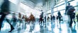 © petrrgoskov - Wide angle view of professionals walking through a large business center with glass architecture, motion blur and active corporate environment.