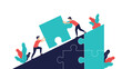 © Md - Business professionals work together to push a large puzzle piece uphill to complete a successful project and achieve common goals.
