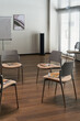 © pressmaster - Empty modern meeting room showing arrangement of chairs in circle with notebooks and pens placed on seats, wooden floor and large windows with blinds allowing natural light