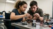 © nadini - Two focused teenagers building a robot together on a workbench in a school makerspace.