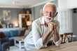 © Jelena Stanojkovic - A smiling middle-aged man looks directly into the camera while standing at the kitchen counter.