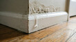© Cliff - Close-up of accumulated water on a baseboard indicating a hidden pipe leak, causing paint peeling, mold growth, and interior water damage