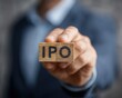 © BagazLK - Biznesmen trzymający drewniany klocek z napisem IPO, symbolizujący pierwszą ofertę publiczną akcji na giełdzie papierów wartościowych.