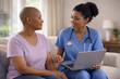 © Valerii Apetroaiei - African american nurse consulting female cancer patient at home