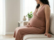 © Jai Izzam - Faceless smiling pregnant woman in elegant dress sitting on sofa holding belly