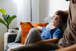 © kleberpicui - Young child receiving nebulizer treatment at home while sitting on sofa, representing pediatric respiratory care, asthma management and family health routine.